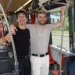 Dva mladí muži se drží za madla v tramvaji a smějí se