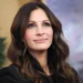 Zasněný pohled ženy s kaštanovými vlasy, je to Julia Roberts