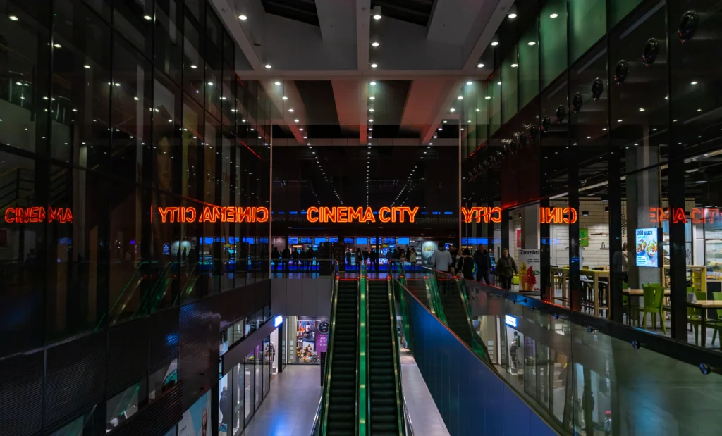 Vchod do obrovského kina Cinema City, blikající neony, spousta uliček