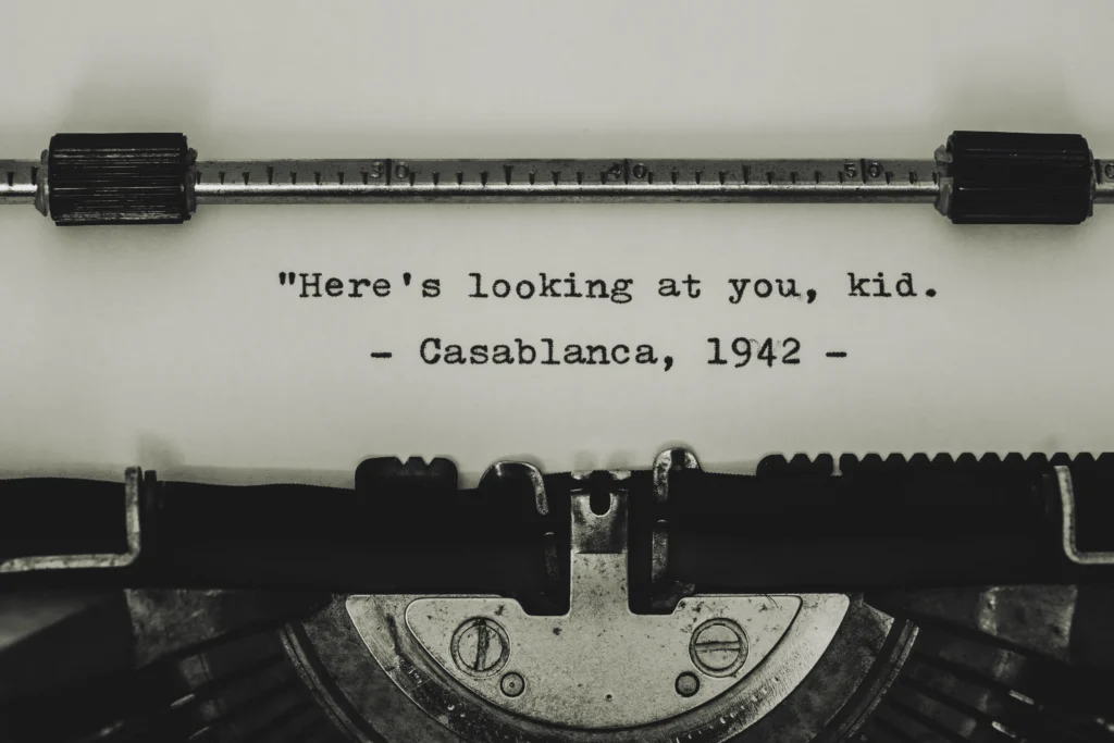 Starý psací stroj a v něm je bílý papír a na něm je napsáno: "Here's looking at you, kid." Casablanca, 1942