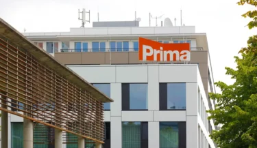 Budova soukromé celostátní televize s jejím oranžovým logem během dne