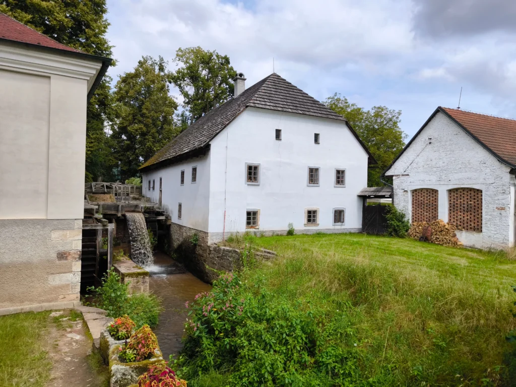 shutterstock_2675107763 - VIPshow Bilé historické vesnické budovy, jedna z nich je mlýn, druhá stavení