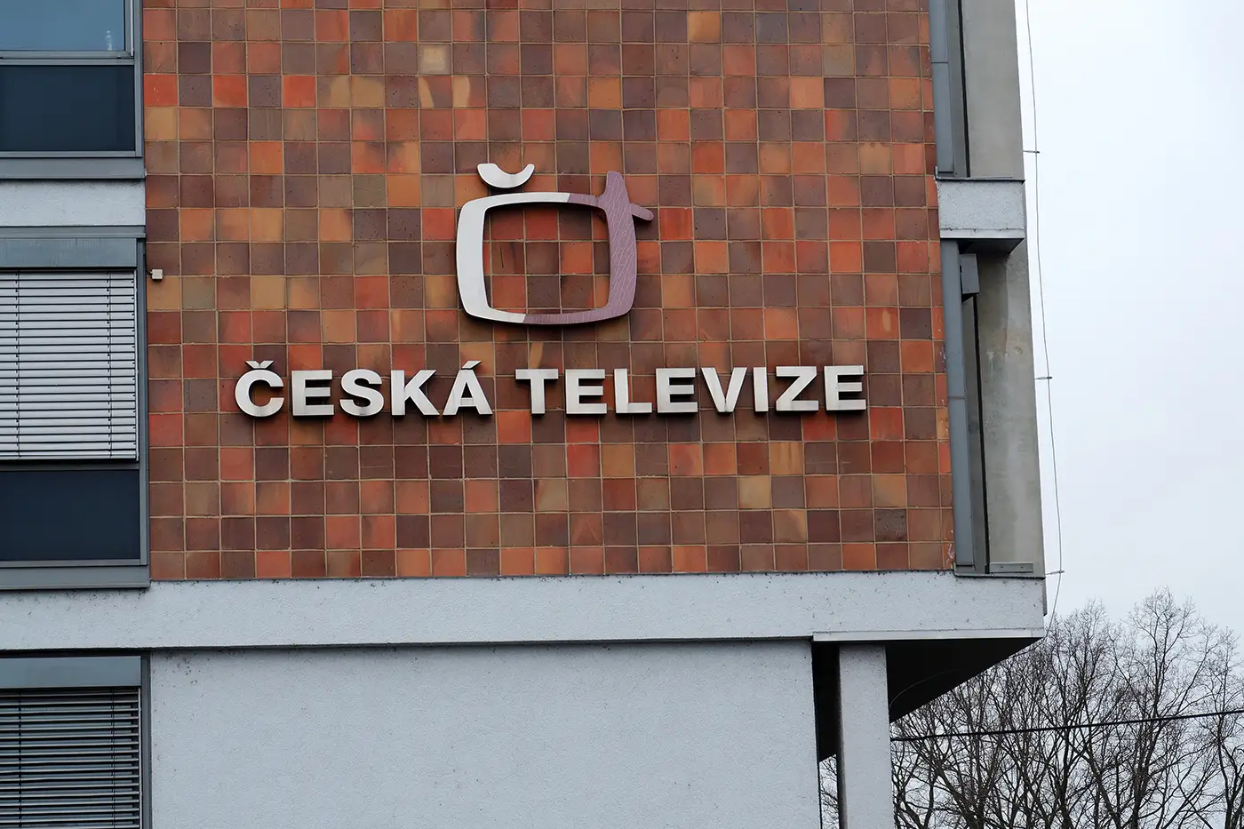 Logo české veřejnoprávní televize na hnědé fasádě budovy