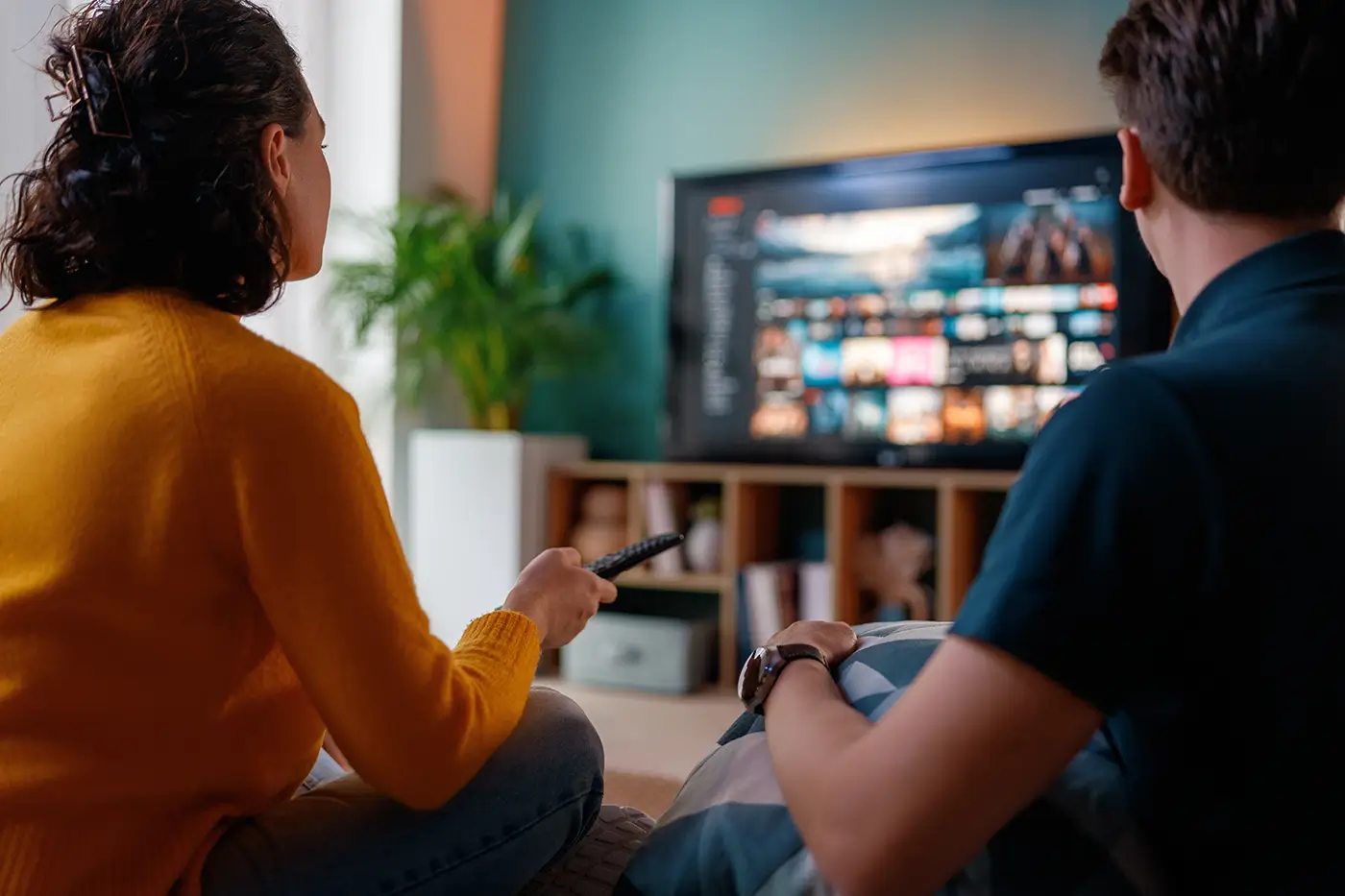 Pár, muž a žena, sedí na pohovce a dívají se na televizi