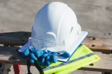 Na lavičce je položená helma, rukavice a výstražná vesta