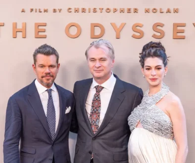 Dva muži a jedna žena se fotí před plakátem filmu Odyssea