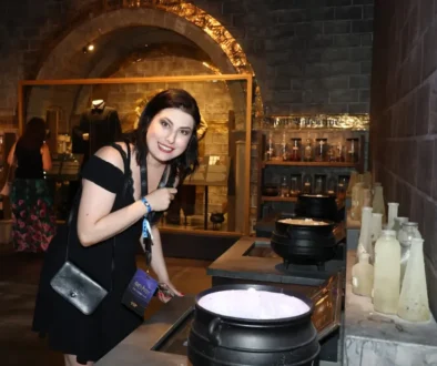 Žena s černými vlasy a v černých šatech se sklání nad stolem