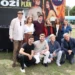 Skupina lidí pózuje před plakátem s nápisem Boží plán