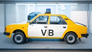 Policejní automobil v bílo-žluté barvě s majáčkem z doby komunismu