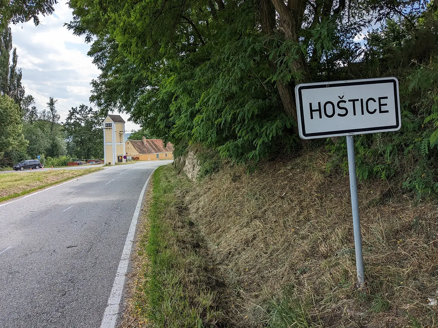 Cedule s názvem jihočeské obce na kraji silnice během bílého dne