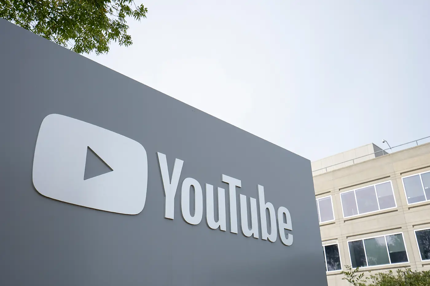 Výrazný šedý panel s logem streamovací platformy YouTube umístěný na ulici