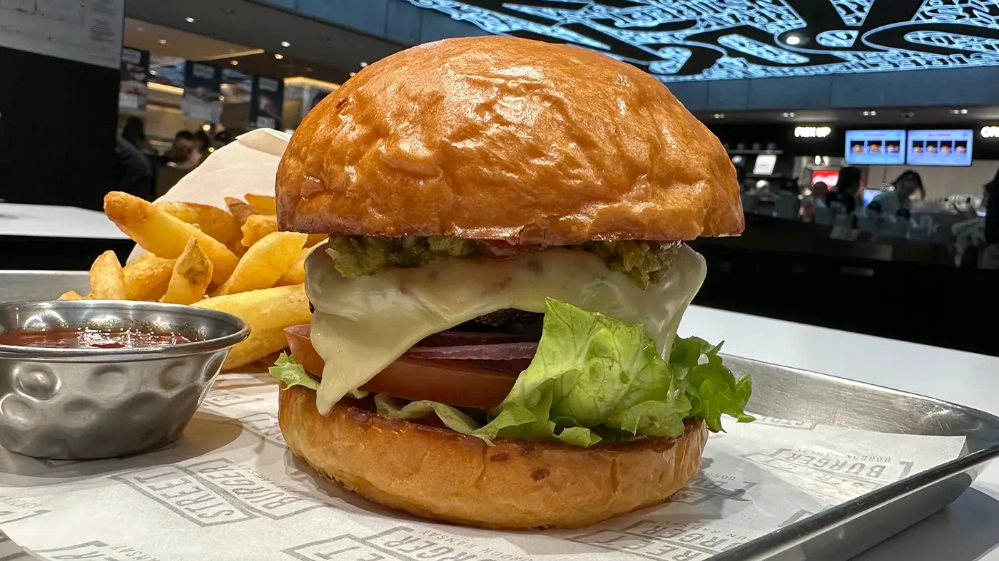 shutterstock_2413809015 - VIPshow Na stole na tácu leží hamburger a za ním jsou hranolky