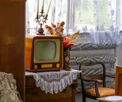 Na stole s háčkovanou dečkou stojí malá stará televize