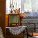Na stole s háčkovanou dečkou stojí malá stará televize