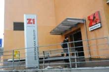 Vchod do soukromé televizní stanice, kterým zrovna během dne prochází jeden člověk