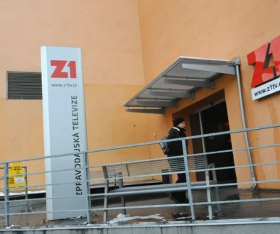 Vchod do soukromé televizní stanice, kterým zrovna během dne prochází jeden člověk
