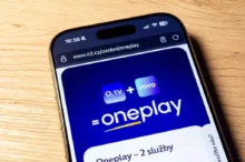 Na hnědém stole leží mobilní telefon s logem streamovací platformy