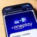 Na hnědém stole leží mobilní telefon s logem streamovací platformy