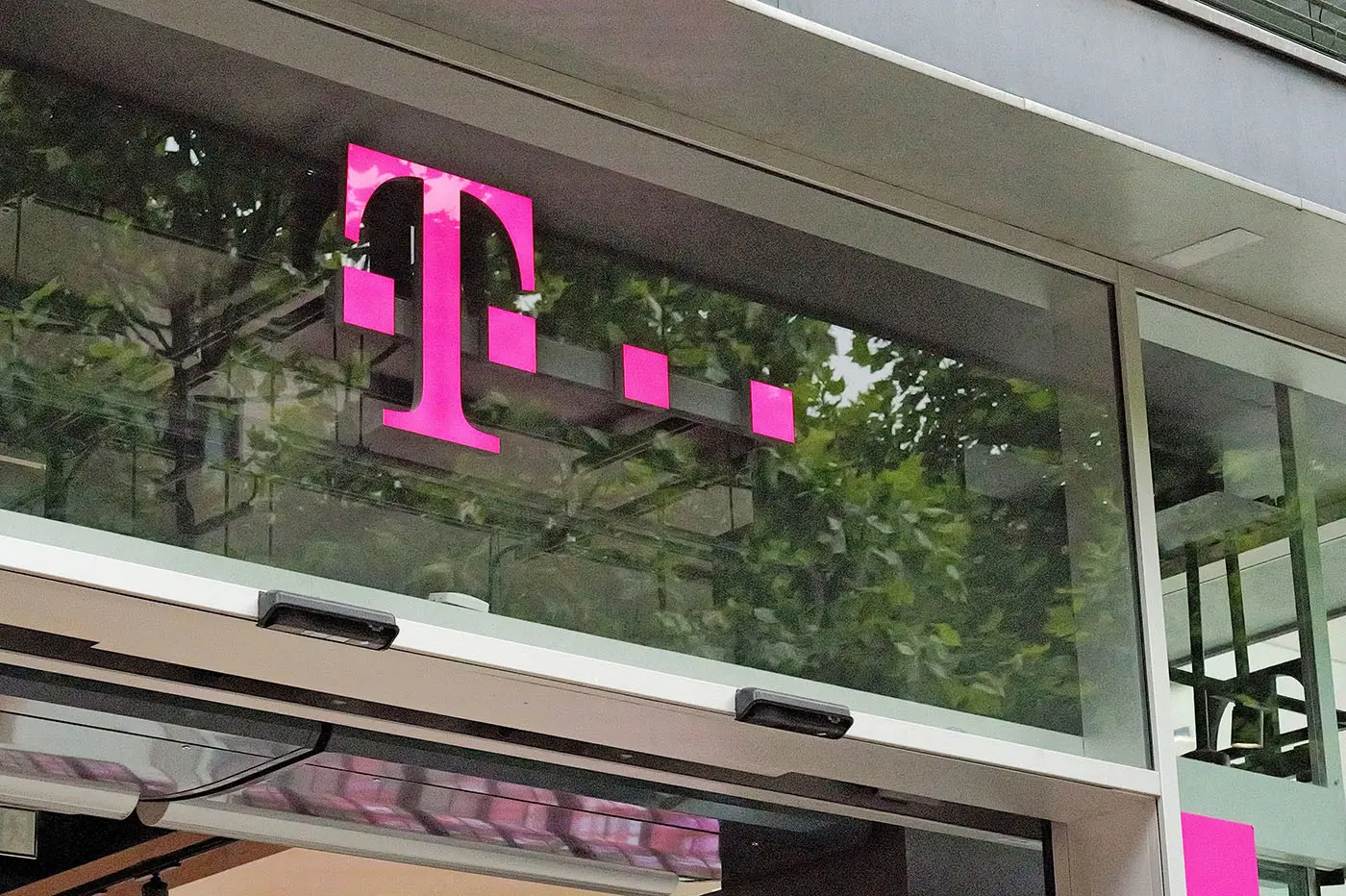 Logo mobilního operátora v odstínu růžové upevněné na skle