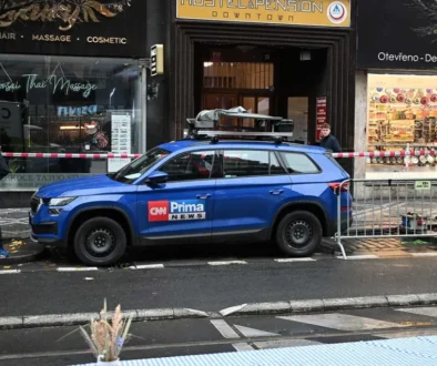 Na ulici stojí modré auto s logem televizní stanice