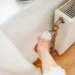Osoba točí termostatem na radiátoru